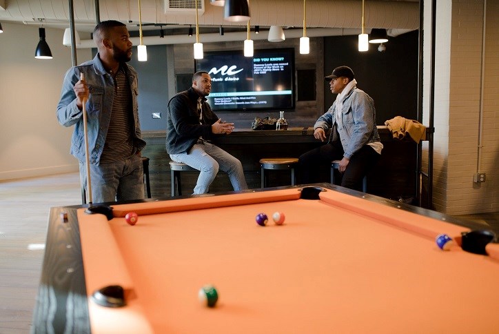 Men playing pool in basement