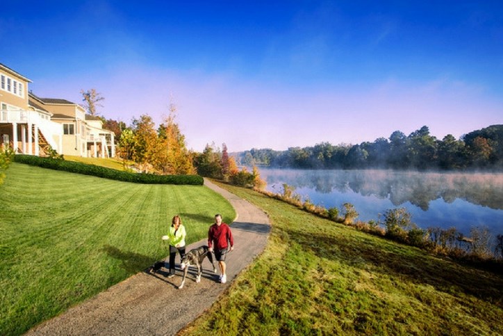 Couple with dog walking around the lake at Sterling on the Lake