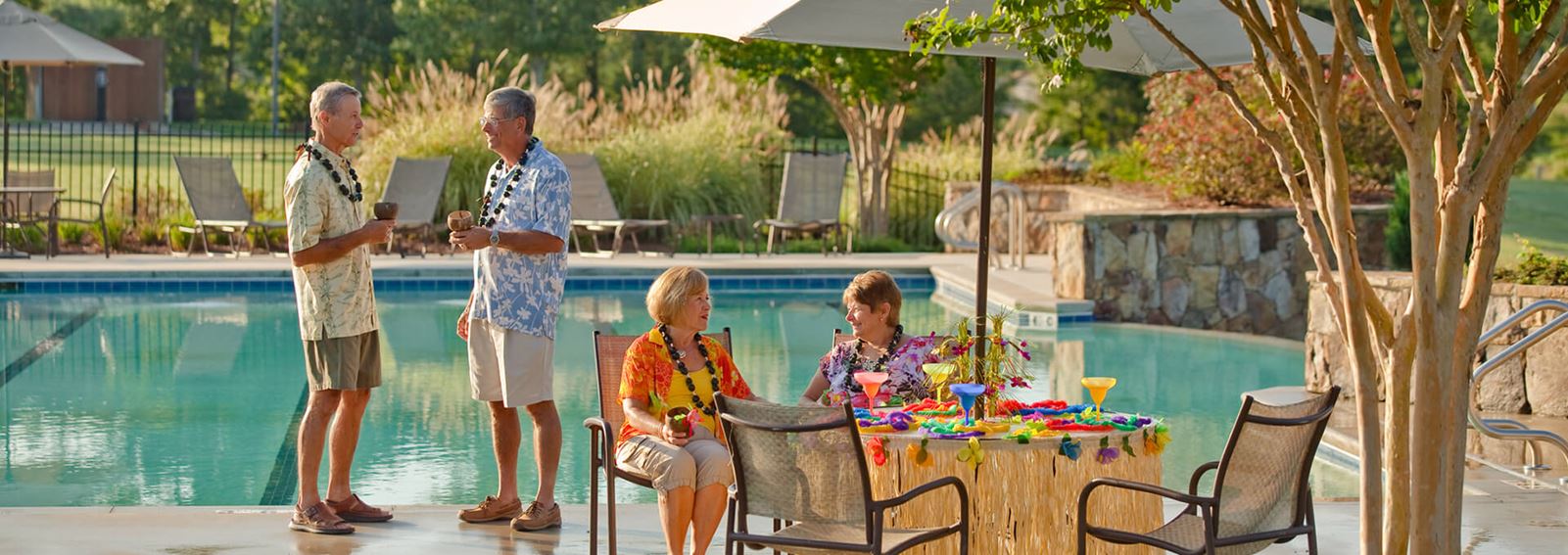 Couples enjoying luau event poolside in Sterling on the Lake.