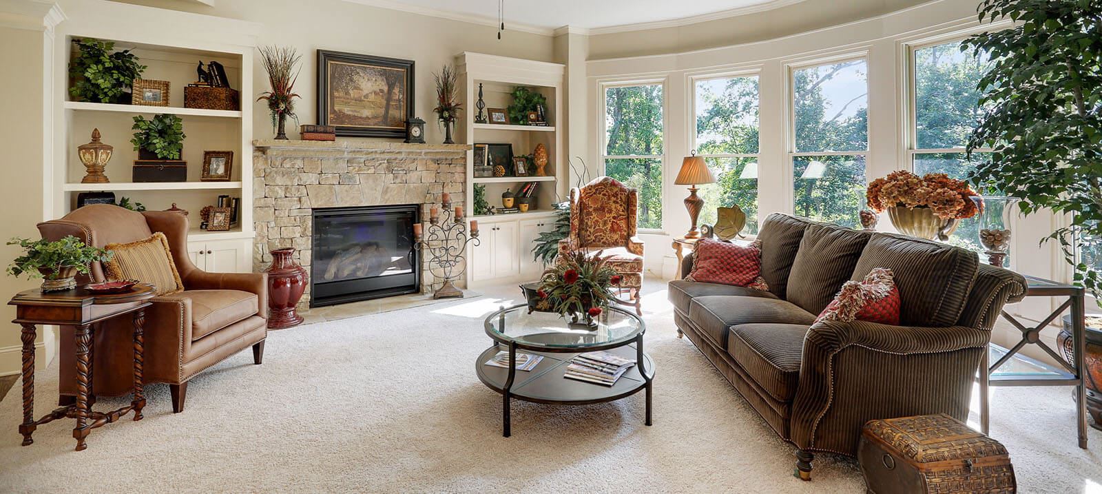 Living area with fireplace and floor to ceiling windows in Harcrest Homes model home.