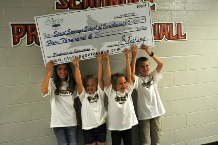 Spout Springs Elementary School Student with check from Sterling on the Lake