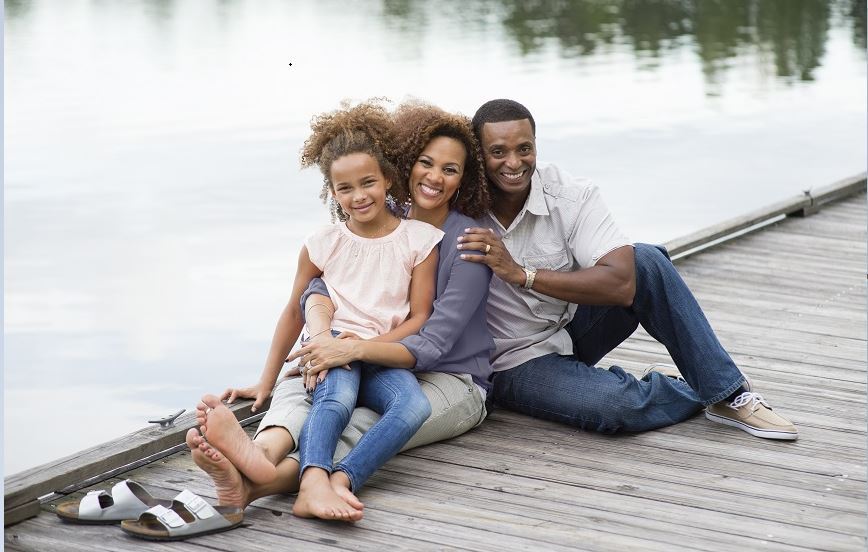 Family sitting together on a dock.