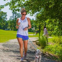 woman walking her dog on trail