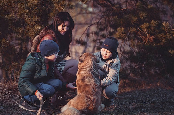 Family hiking with their dog along a trail in Sterling on the Lake.