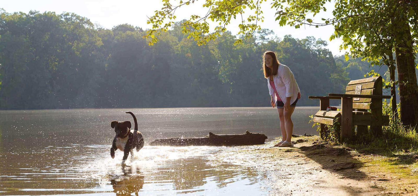 Woman playing with her dog around Lake Sterling in Sterling on the Lake.