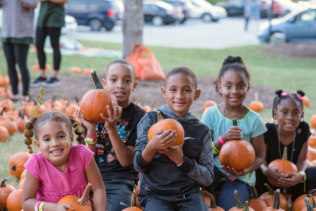 Kids holding pumpkins at fall festival