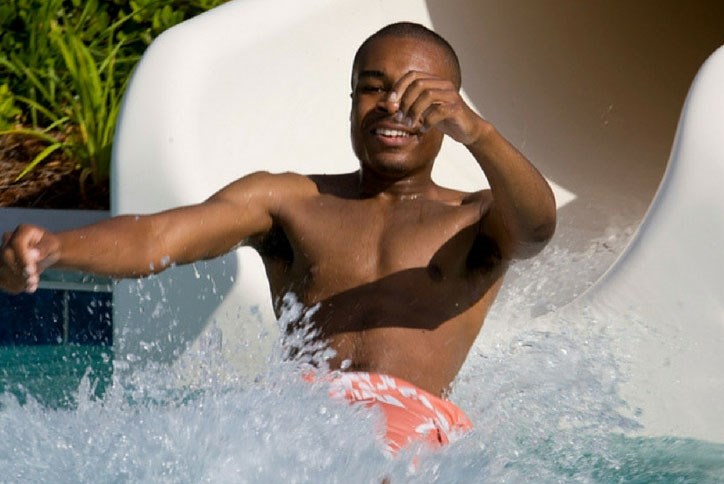 Older kid splashing down the waterslide