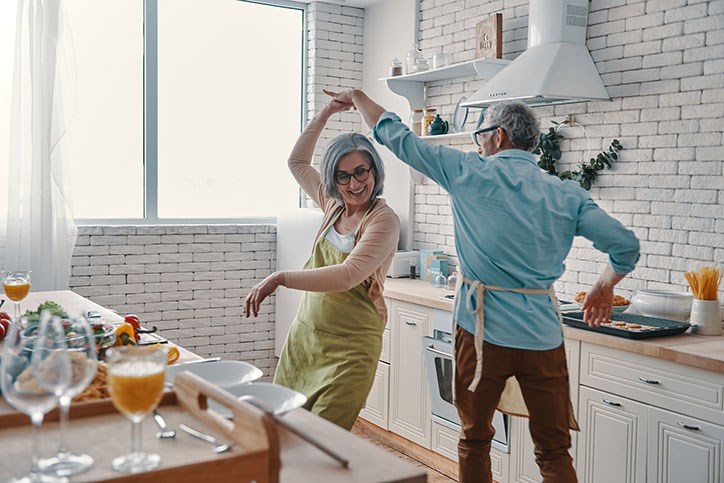 Retired couple dancing in their kitchen